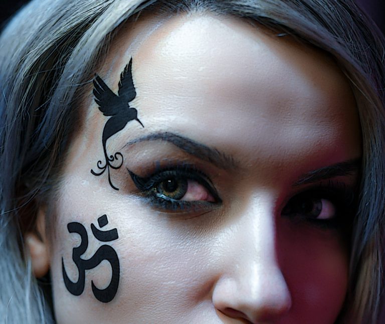 Tatuaje falso en la cara. Tatuaje de pájaro junto al ojo.